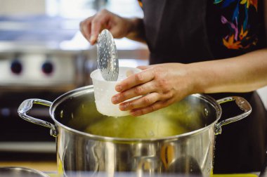 Atölyede peynir yapma süreci. Peynir yapan adamın elleri, yakın plan. Film sesi.