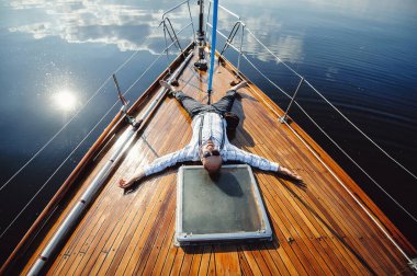 Yatında dinlenen başarılı bir işadamı ve yatçı. İyi bir hayat.