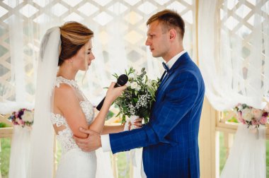 Gelin, elinde mikrofon tutan bir düğün konuşması olduğunu söylüyor. Sevgili çift, gelin ve damat düğün günlerinde. Düğün töreninde güzel bir gelin ve şık bir nişanlı portresi..