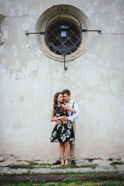 爱幸福的夫妻 男人在灰色复古墙的背景上亲吻女孩 男人和女人走过城市街道 — 图库照片