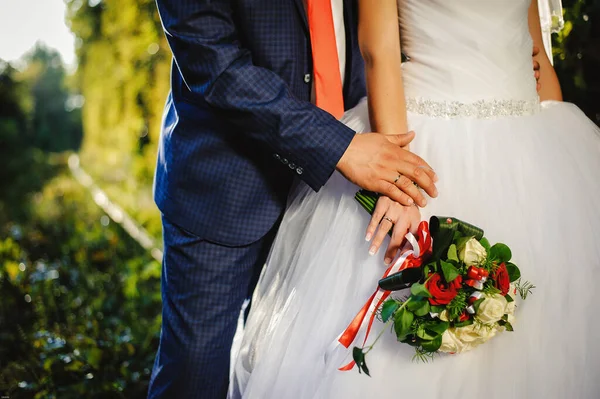 close-up photo, elegant chic luxury fashion wedding bouquet. the groom and the bride, holding hands, standing in outdoors.