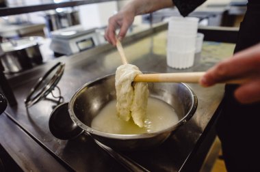 Ev yapımı peynir üreticisi taze sütle el yapımı mozzarella üretir. Kavram: Gelenek, İtalya, mozzarella. Mozzarella yapma süreci..