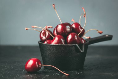 Siyah arka plan üzerine taze yakut kiraz. Moody yakından karanlık: natürmort