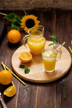 Cam buz küpleri ve portakal ahşap masa üzerinde taze sıkılmış portakal suyu. Sonbahar rahat rustik ruh natürmort