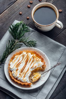 Lezzetli Noel tatlısı. Beze ve koyu ahşap masa üzerinde kahve ile limon tart. Noel tatil dekorasyon