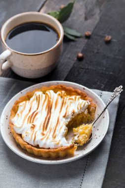 El Siyah bir ahşap arka plan üzerinde tart, tartı ile limon lor ve beze ve kahve yaptı. Seçici odak, üstten görünüm