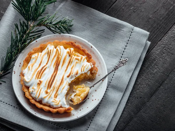 Lezzetli Noel tatlısı. Beze ve koyu ahşap masa üzerinde kahve ile limon tart. Noel tatil dekorasyon.