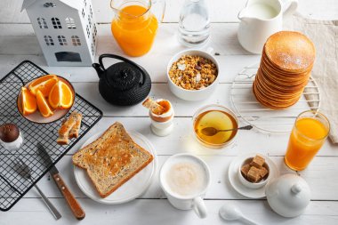 Kavramı, çeşitli sabah gıda - krep, rafadan yumurta, kızarmış ekmek, yulaf ezmesi, gevrek, meyve, kahve, çay, portakal suyu, süt beyaz tahta masada yemek sağlıklı bir kahvaltı