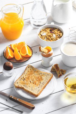 Kavramı, çeşitli sabah gıda - krep, rafadan yumurta, kızarmış ekmek, yulaf ezmesi, gevrek, meyve, kahve, çay, portakal suyu süt beyaz tahta masada yemek sağlıklı bir kahvaltı. Üstten Görünüm