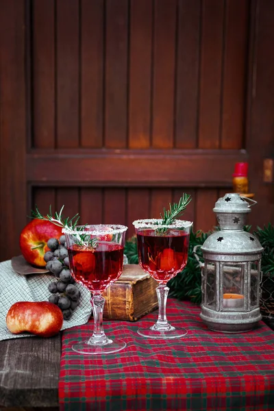 Bodegón de Navidad, dos copas con bebida roja de frambuesa decoradas con romero, estilo vintage de moda antigua . — Foto de Stock