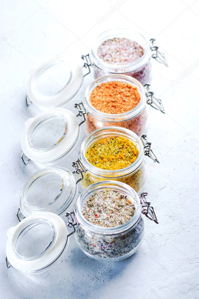 Four jars with different flavoured mixes of salt and spices. Himalayan and sea salt mixed with various peppers and herbs.