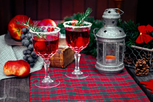 Bodegón de Navidad, dos copas con bebida roja de frambuesa decoradas con romero, estilo vintage de moda antigua . — Foto de Stock