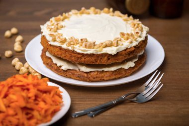 Havuçlu kek, fındıklı fındık ve ahşap masada rendelenmiş havuç, havuçlu bisküvi ve fındıklı ekşi kremayla pişirilmiş turta.