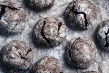 Parşömen zemininde pudra şekerli birkaç mermer kahverengi kurabiye.