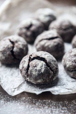 Parşömen zemininde pudra şekerli birkaç mermer kahverengi kurabiye.