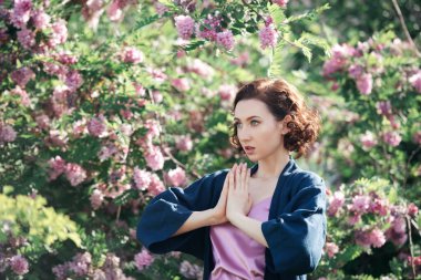 Akasya çiçeğinin arka planında genç, güzel, hayalperest bir kız. Romantik bir kadının açık hava portresi..