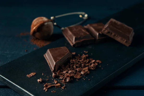 Kousky Čokolády Kousky Čokolády Cedník Kakaem Tmavomodrém Dřevěném Stole — Stock fotografie