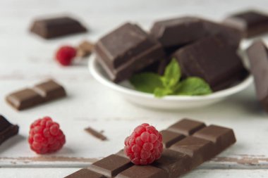 Ahududu, çikolata parçaları, çikolata parçacıkları ve nane şekeri beyaz Provence tarzı masada..