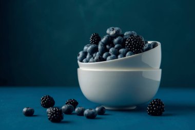 Mavi masada yaban mersini ve böğürtlenli beyaz kase.. 