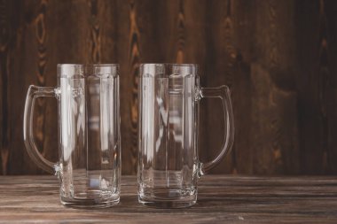 Ahşap arka planda boş bira bardakları. Büyük cam kupalar..