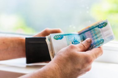 Erkeklerin elinde 5000 ve 1000 rublelik banknotlar var. Rus parası. Rusça 