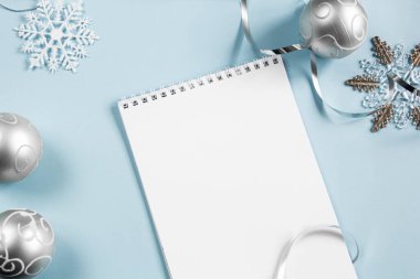 Mavi arka planda bir Noel planı. Düz çizgi. Telefon, dizüstü bilgisayar, şarj kablosu. Yakın plan. Bir yazıt için yer.