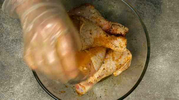 Σεφ ανάμειξη ακατέργαστων πόδια κοτόπουλο για μπάρμπεκιου ή τηγάνισμα σε βαθύ γυάλινο μπολ με μαρινάτα. Μπαχαρικά και σάλτσα αναμειγνύονται με πόδια κοτόπουλου. Κοντινό πλάνο. — Αρχείο Βίντεο