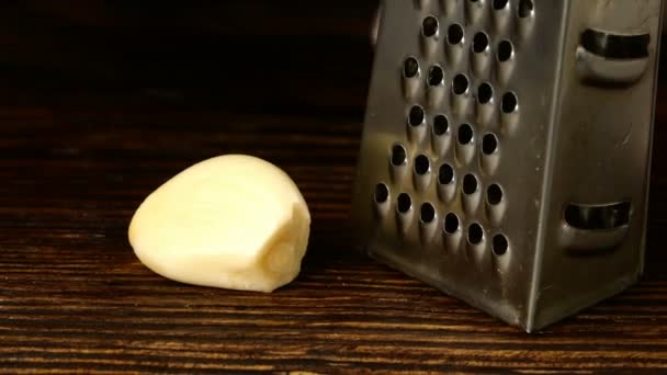 Chef mani strofinando spicchio d'aglio su piccola grattugia metallica su bordo cucina. Primo piano . — Video Stock