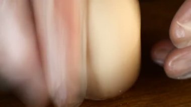 Parmakları kaynamış yumurtalardan yumurta kabuğu soyan insan elleri. Yakın plan..