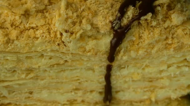 Puff szelet étvágygerjesztő Napóleon torta öntik a tetején csokoládé fondant. Közelkép. — Stock videók