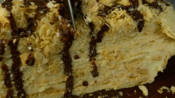 Slice of puff appetizing Napoleon cake cut into two parts with metal knife. Close-up. — Stock Video