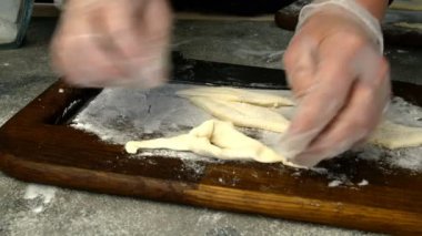 Şefin yaptığı dilimlenmiş hamur hamuru, khvorost ya da faworki kurabiyelerinden lezzetli hamur işleri yapmaya kadar. Yakın plan. Makro.