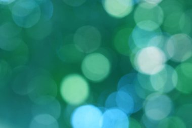 Soyut bokeh, doğal yeşil ve mavi arkaplan, yaz boyunca güzel bulanık, ağaçtaki yapraklardan alınan mavi-yeşil bir bokeh ve sarı-mavi bir ışık var.
