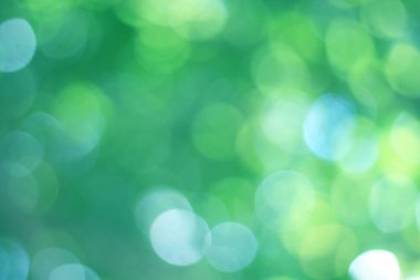 Soyut bokeh, doğal yeşil ve mavi arkaplan, yaz boyunca güzel bulanık, ağaçtaki yapraklardan alınan mavi-yeşil bir bokeh ve sarı-mavi bir ışık var.