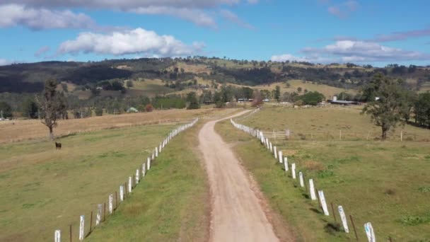 Images aériennes d'une piste de terre avec une clôture blanche sur une ferme dans la région de l'Australie