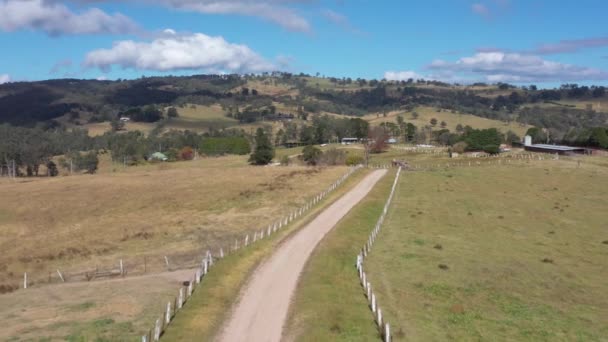 オーストラリア地方の農場に白い柵があるダートトラックの空中映像 — ストック動画