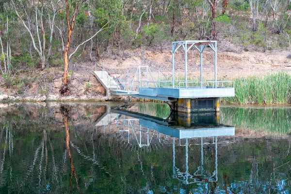 A pumping station platform in a water supply reservoir with a reflection in the water