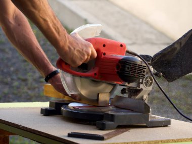 Bir marangozun yakınına daire şeklinde testere ile tahta keserek yaklaşmak.