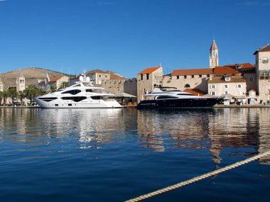 Trogir, Hırvatistan Eylül 2020. Trogir, arkasında güzel gemilerin durduğu pitoresk bir liman. Arkalarında eski kasaba ve duvarları olan bir kale.