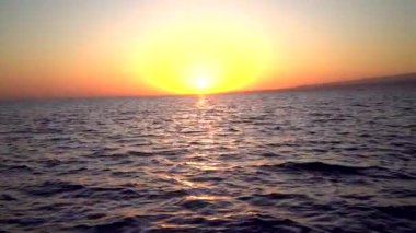 Deniz dalgalarının yansımasıyla gün batımı görüntüsü 