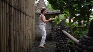 Genç adam yaz terasında dışarıda qigong egzersizleri yapıyor. İyileşme ve ruhsal sağlık, Bali, Endonezya