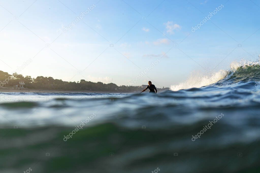 Surfer in ocean on big waves. Bali surfing aerial shot. Healthy Active Lifestyle.