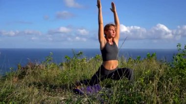 Fitness genç esmer kadın sabahları plajda yoga yapıyor.