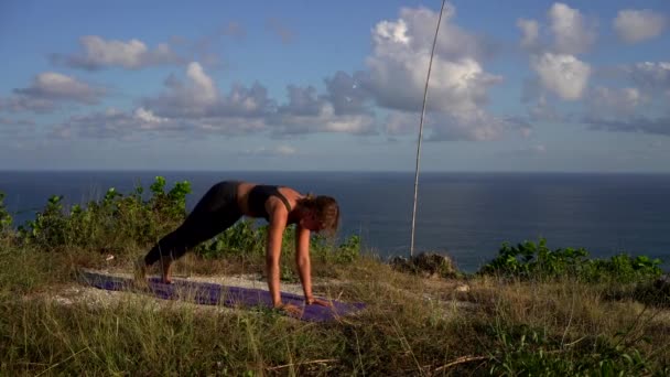 素晴らしい女の子練習ヨガオンザビーチで朝の日に山の背景 — ストック動画