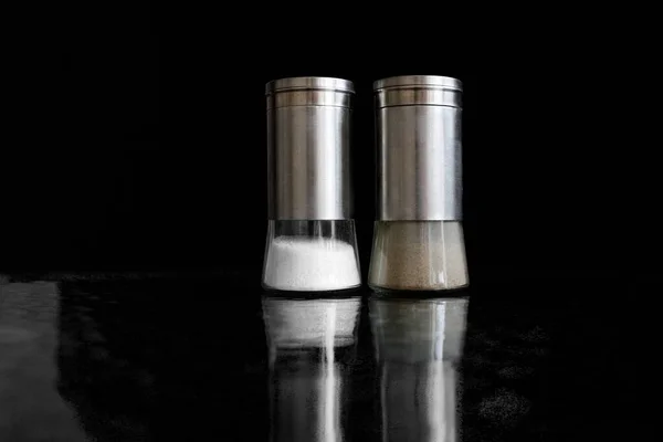 Siyah arkaplanda tuzluk ve biber karıştırıcı