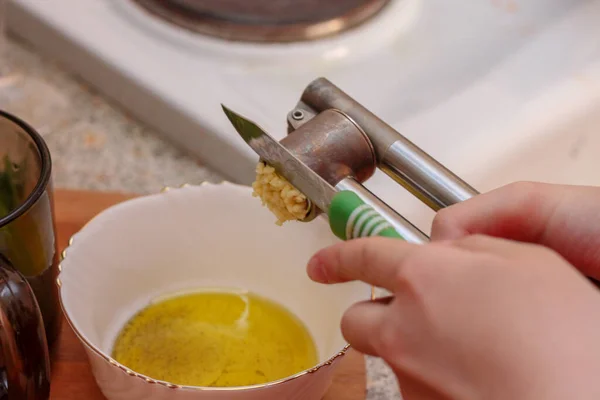 Kız sarımsak eziyor. Evde yemek pişirmek..