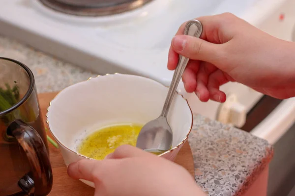 Kız sosu karıştırıyor. Evde yemek pişirmek..