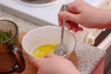 Kız sosu karıştırıyor. Evde yemek pişirmek..