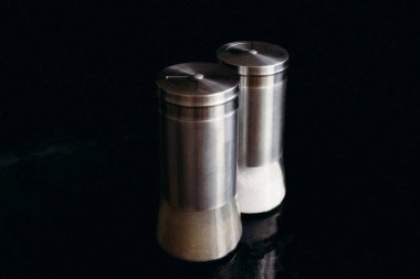 Siyah arkaplanda tuzluk ve biber karıştırıcı