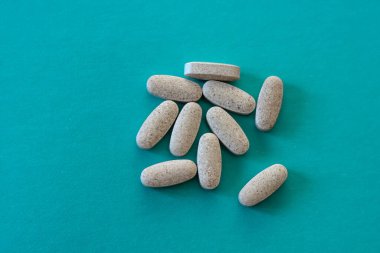 Tedavi için ilaçlar. Yeşil zemin üzerindeki tabletlerdeki vitaminler